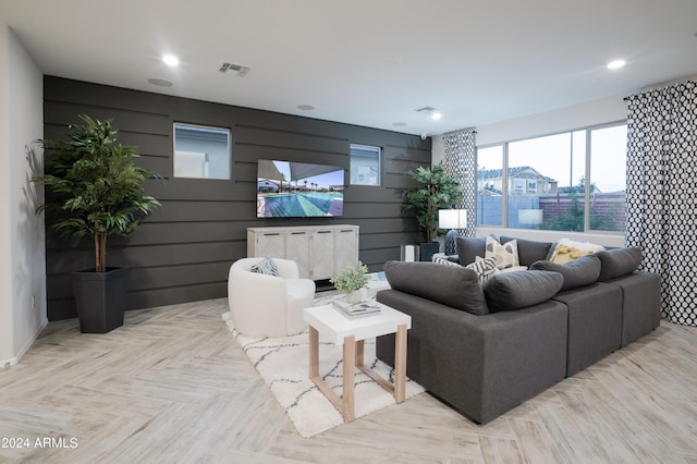 living room featuring light parquet floors and wood walls