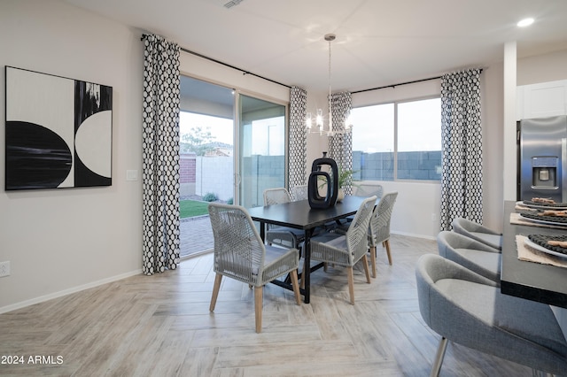 dining area featuring light parquet floors and a notable chandelier