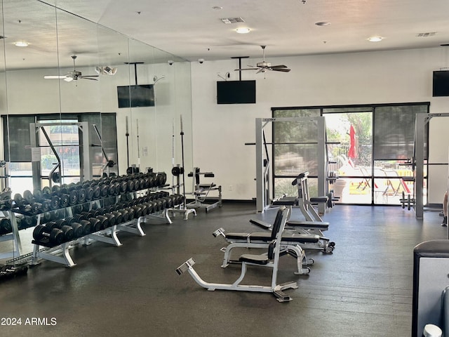 exercise room featuring a high ceiling and ceiling fan