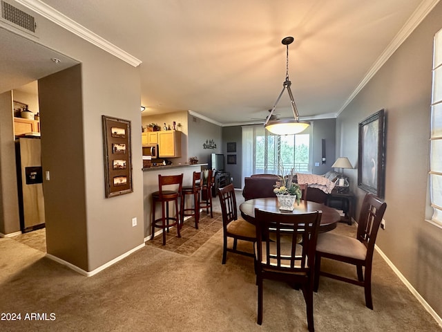 carpeted dining room featuring crown molding