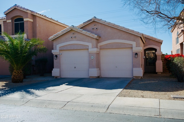 mediterranean / spanish-style home with driveway, an attached garage, a tile roof, and stucco siding