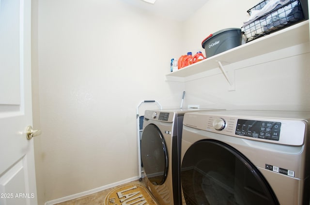 clothes washing area with laundry area, washing machine and clothes dryer, and baseboards