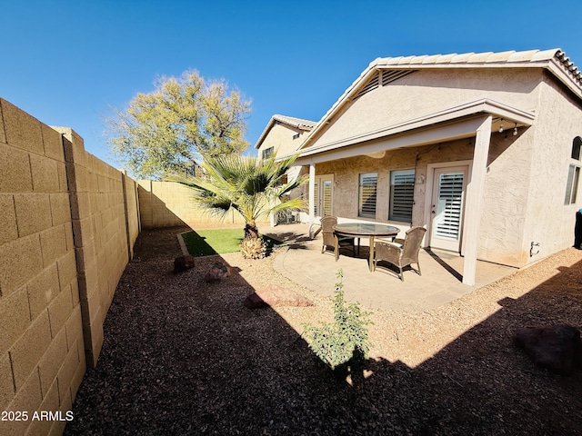 back of property with a patio, a fenced backyard, a tiled roof, and stucco siding