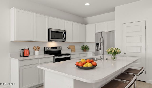 25484 W Graham Trl, Buckeye, AZ 85326 - kitchen with stainless steel appliances, white cabinets, light countertops, a center island with sink, and recessed lighting