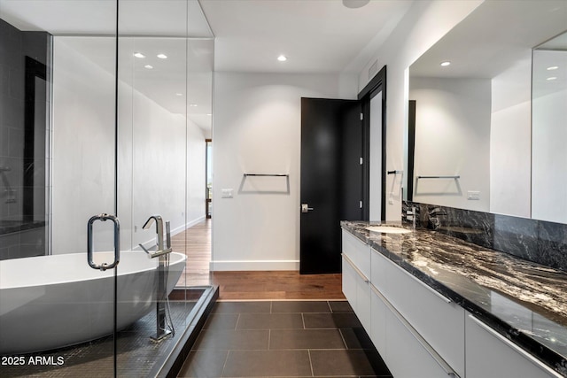 bathroom featuring recessed lighting, a soaking tub, a stall shower, vanity, and tile patterned floors