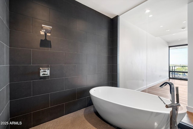 full bathroom with a soaking tub, tile walls, wood finished floors, and recessed lighting