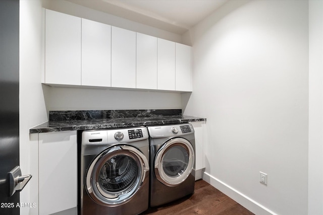 clothes washing area featuring baseboards, dark wood-type flooring, cabinet space, and washer and dryer