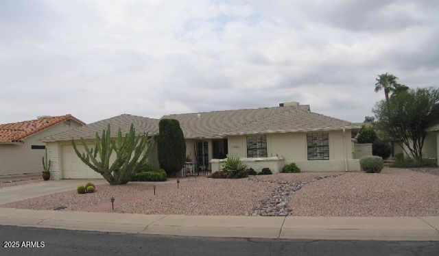 single story home featuring concrete driveway, an attached garage, and stucco siding