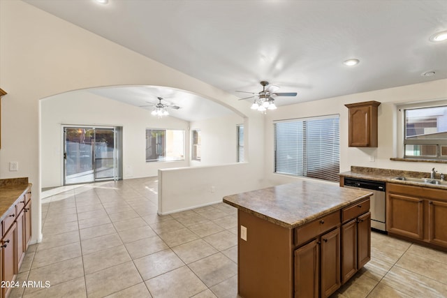 kitchen with dishwasher, a center island, sink, vaulted ceiling, and light tile patterned floors