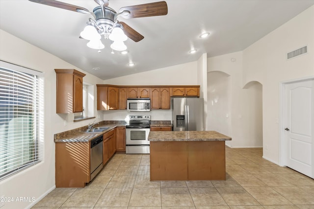 kitchen featuring ceiling fan, a kitchen island, vaulted ceiling, light tile patterned floors, and appliances with stainless steel finishes