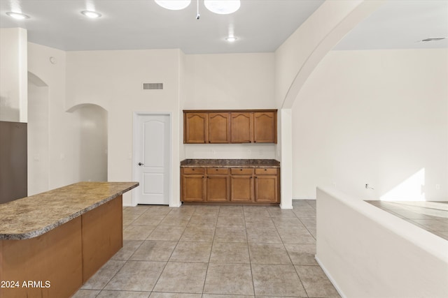 kitchen featuring light tile patterned floors and a towering ceiling