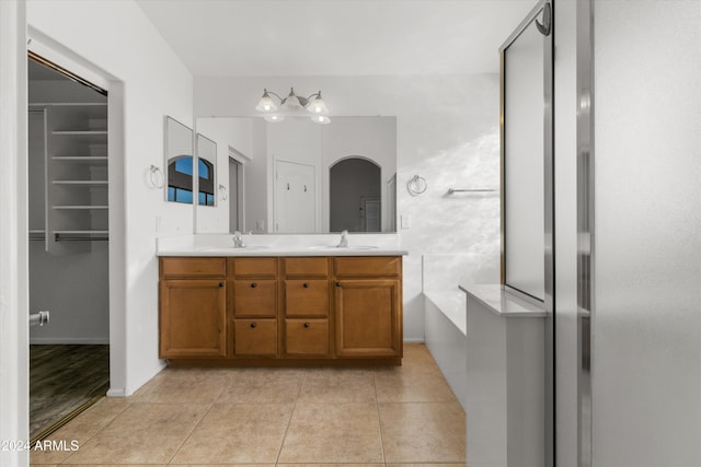 bathroom with tile patterned flooring, vanity, and a washtub