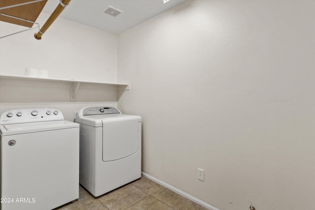 laundry room featuring separate washer and dryer and light tile patterned floors