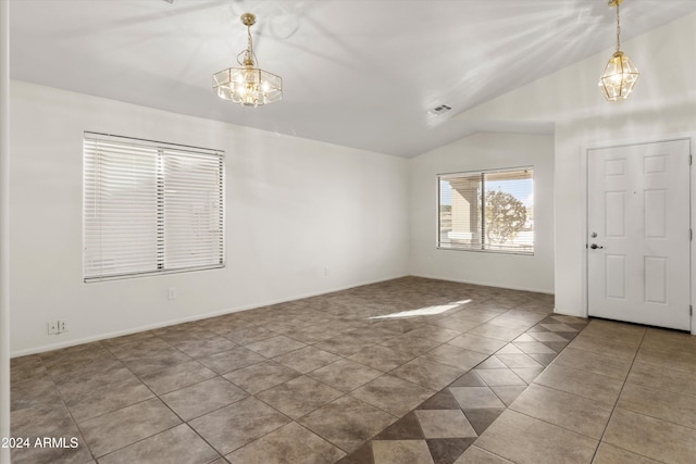 foyer with tile patterned flooring, vaulted ceiling, and a notable chandelier