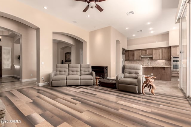 5226 S Fairchild Ln, Chandler, AZ 85249 - living area featuring a ceiling fan, recessed lighting, light wood-style floors, baseboards, and arched walkways