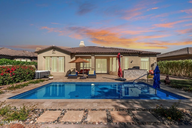 5226 S Fairchild Ln, Chandler, AZ 85249 - back of house at dusk featuring a tiled roof, stucco siding, a chimney, a patio, and exterior kitchen