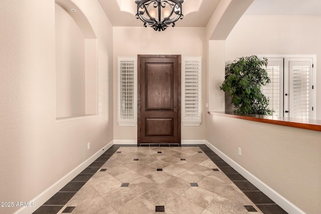5226 S Fairchild Ln, Chandler, AZ 85249 - entryway with arched walkways, inlaid floor details, dark tile patterned floors, and a chandelier
