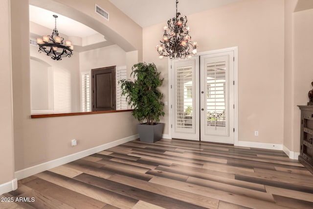 5226 S Fairchild Ln, Chandler, AZ 85249 - unfurnished dining area featuring a chandelier, arched walkways, wood finished floors, and french doors
