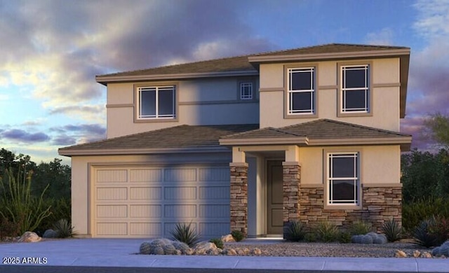 view of front facade featuring stone siding, driveway, an attached garage, and stucco siding