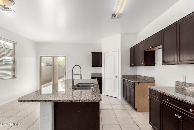 kitchen featuring visible vents, light stone counters, a sink, and light tile patterned flooring