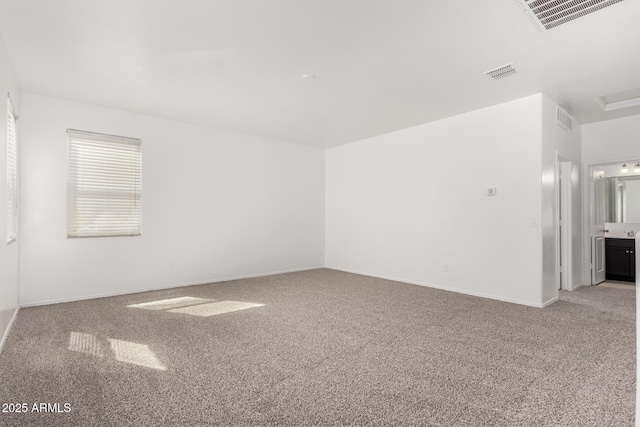 spare room featuring visible vents, light carpet, and baseboards