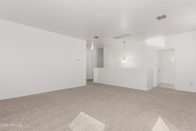 empty room with light carpet, visible vents, and baseboards