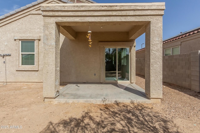 back of house featuring a patio area, fence, and stucco siding