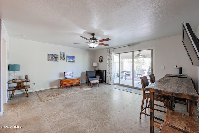 dining area featuring ceiling fan, light tile patterned floors, and a textured ceiling