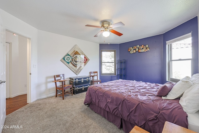 bedroom featuring carpet flooring, ceiling fan, and a textured ceiling