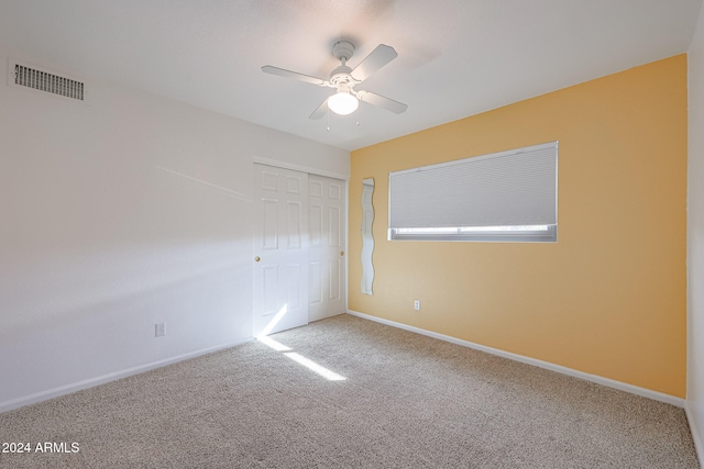 unfurnished room with carpet and ceiling fan