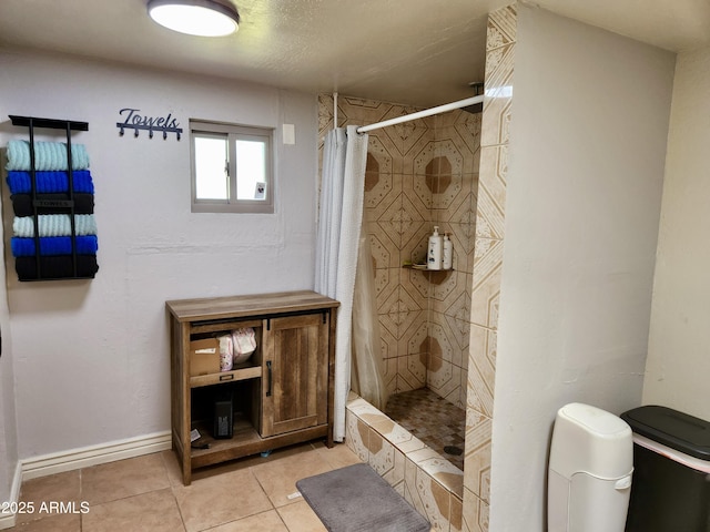 bathroom featuring a shower stall, baseboards, and tile patterned floors