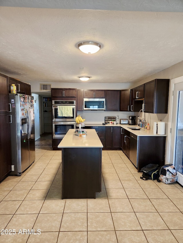 kitchen with visible vents, light countertops, light tile patterned floors, appliances with stainless steel finishes, and a sink