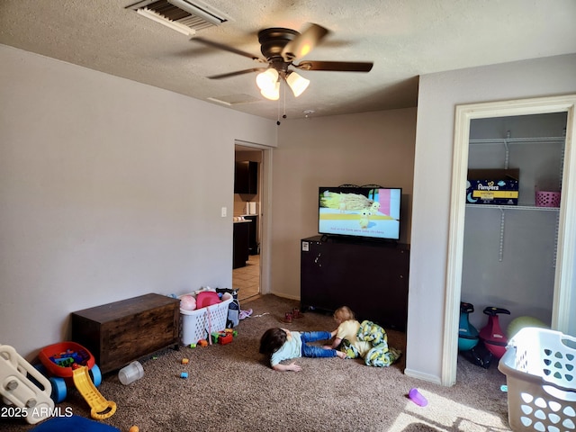 bedroom with visible vents, baseboards, carpet floors, a textured ceiling, and a ceiling fan