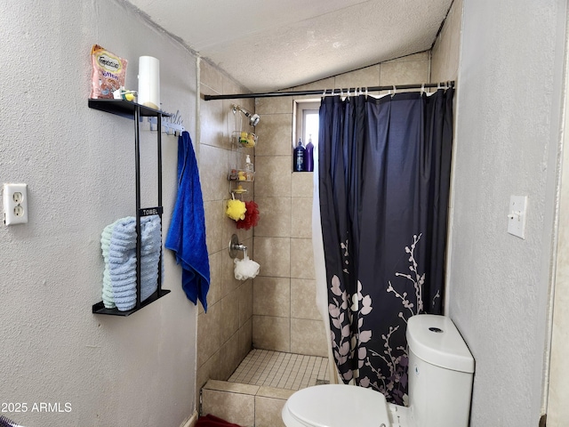 full bathroom with a tile shower, vaulted ceiling, a textured ceiling, toilet, and a textured wall