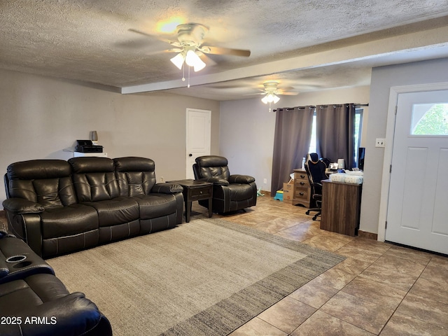 living room with ceiling fan, a textured ceiling, and baseboards