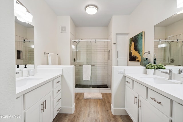 bathroom with hardwood / wood-style flooring, vanity, and an enclosed shower