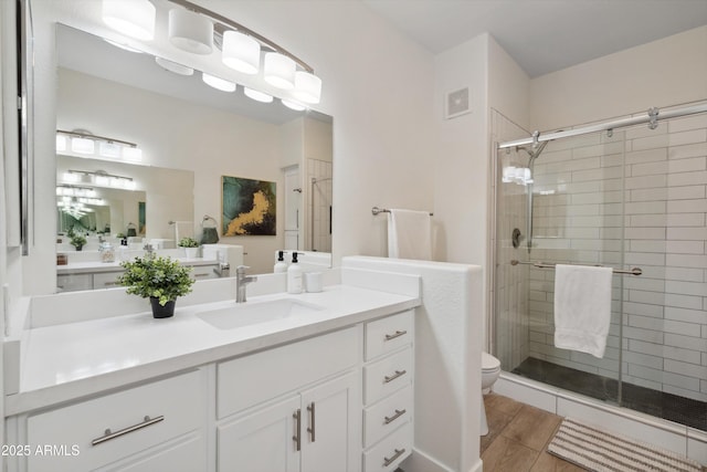 bathroom with walk in shower, vanity, toilet, and hardwood / wood-style floors