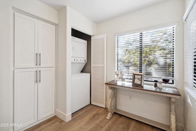 washroom featuring stacked washing maching and dryer and light hardwood / wood-style floors