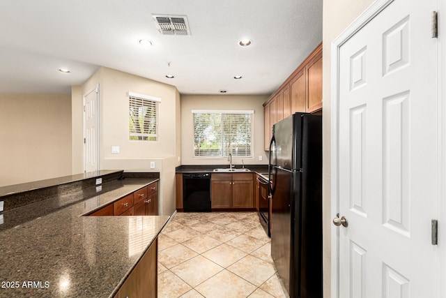 1250 S Rialto Unit 78, Mesa, AZ 85209 - kitchen with black appliances, brown cabinets, light tile patterned floors, dark stone countertops, and recessed lighting