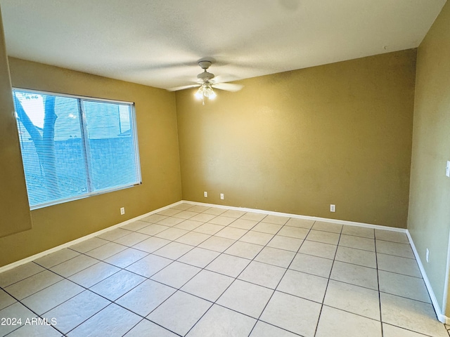 tiled empty room featuring ceiling fan