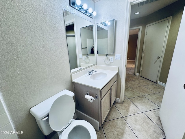 bathroom featuring tile patterned flooring, vanity, and toilet