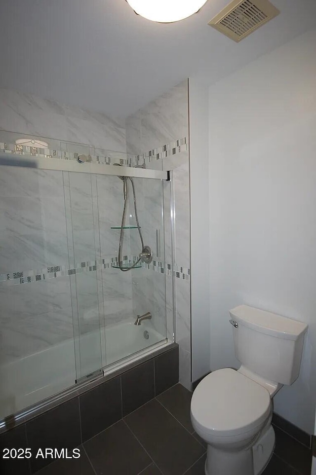 bathroom with tiled shower / bath, visible vents, toilet, and tile patterned floors