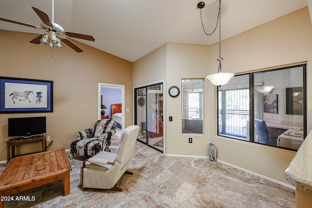 living room featuring ceiling fan, a textured ceiling, and vaulted ceiling