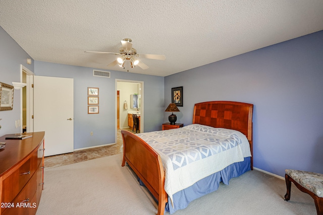 carpeted bedroom with connected bathroom, a textured ceiling, and ceiling fan