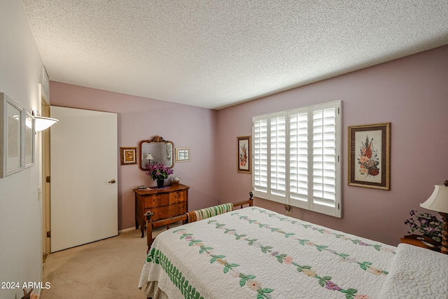 bedroom featuring a textured ceiling and light colored carpet