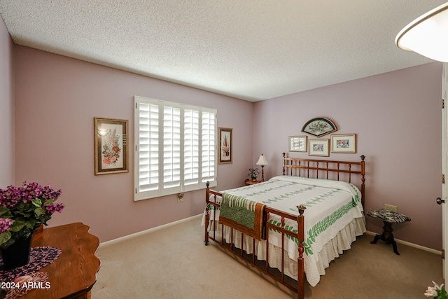 bedroom with a textured ceiling and light carpet