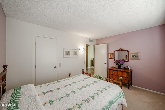 carpeted bedroom featuring a textured ceiling and a closet