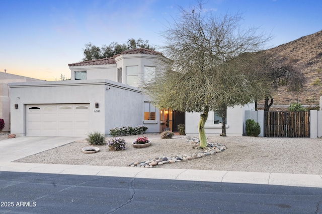 view of front facade with a garage, a tile roof, concrete driveway, and stucco siding