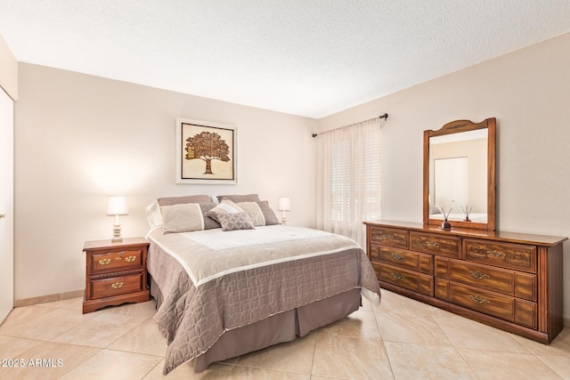 bedroom featuring light tile patterned floors and a textured ceiling