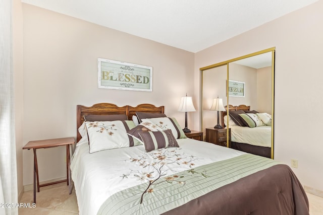 bedroom featuring a closet, tile patterned floors, and baseboards